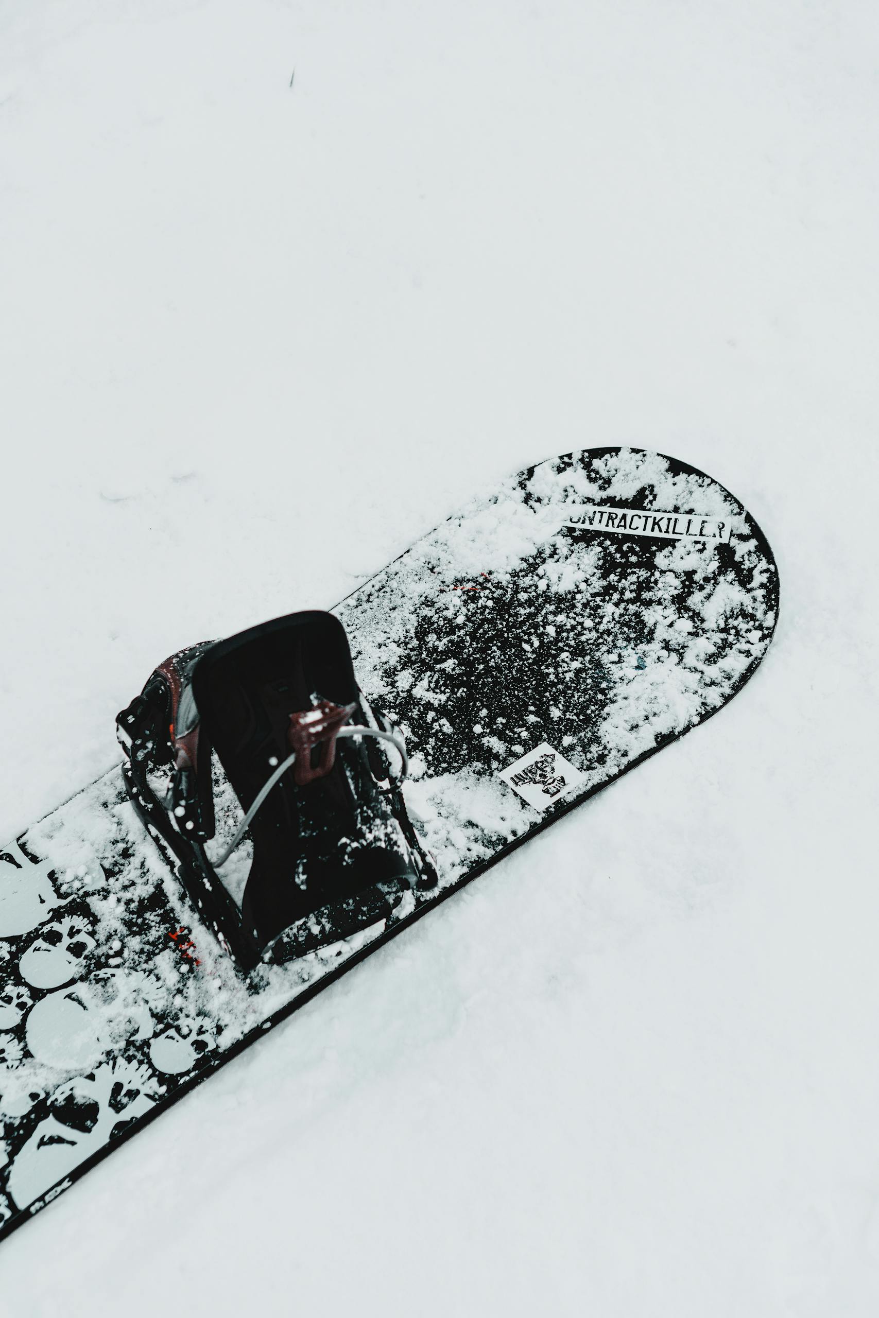 A snowboard resting in fresh snow, capturing the essence of winter sports.